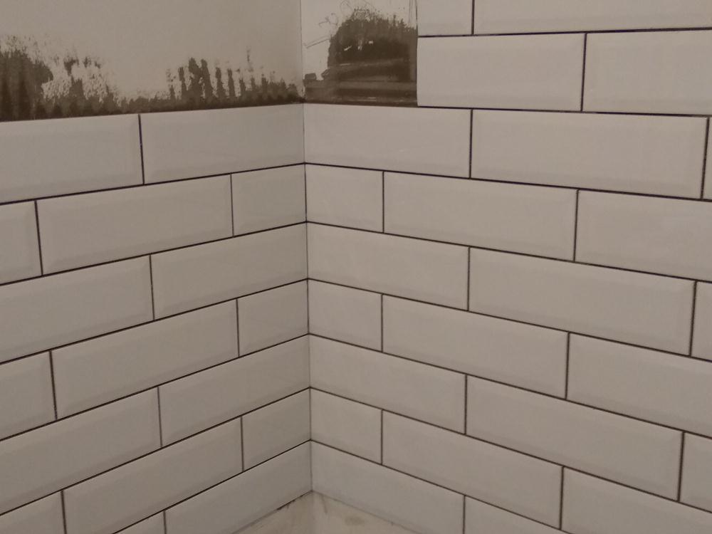 Плиточник устанавливает подвесные потолки.
